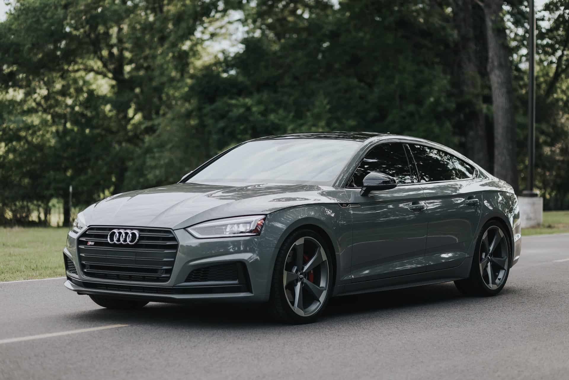 Audi sedan parked on the side of a road surrounded by trees.